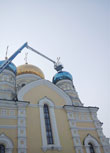 Фото. Владивосток. Февраль 2013 года. На купол Покровского кафедрального собора, после ремонта, вновь установлен крест. Для высотных работ привлекли спецтехнику МЧС