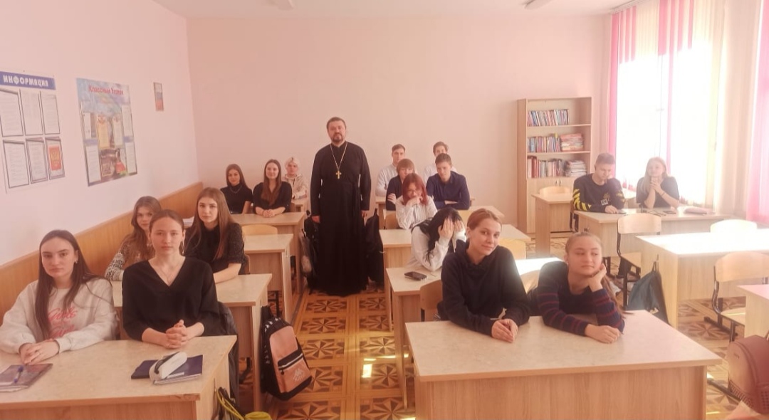 Священник беседует со школьниками о семейных ценностях.